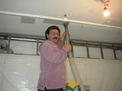 A man in pink jacket holding up a pole.