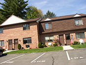 A large brick building with two windows and a flag on the front.