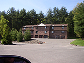 A large brick building with trees in the background.