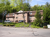 A large brick building with cars parked in front of it.