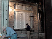 A man standing next to a building with a ladder.