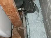 A person is working on the wall of an attic.