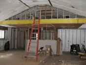 A room being remodeled with a ladder and some boxes.