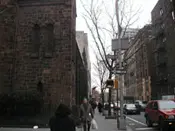 A busy street with people walking and cars driving on it.