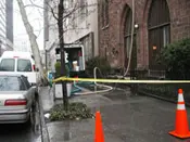 A fire hydrant is taped off near the side of a building.