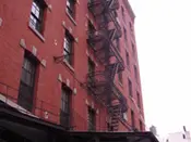 A fire escape on the side of an old brick building.