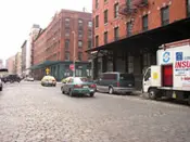 A street scene with cars and trucks on the side of the road.