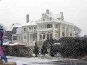 A large white house with snow on the roof.