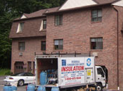 A truck is parked in front of a brick building.