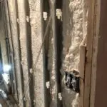 A wall with insulation and wires on it